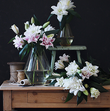 oppsats-av-liljer-paa-bord-av-tre.jpg