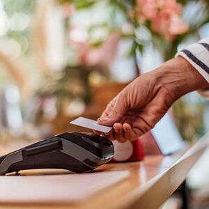 Hånd som legger bankkort på en kortterminal