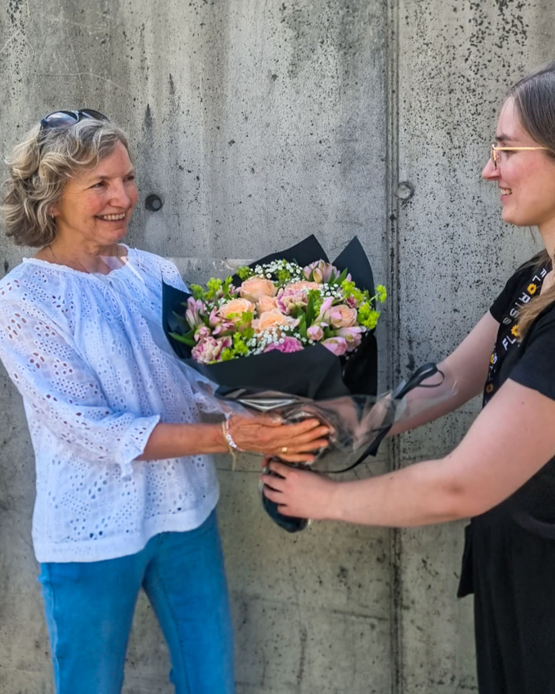 Blomsterdekoratøren Veronica overrekker bursdagsbuketten til den heldige vinneren Main