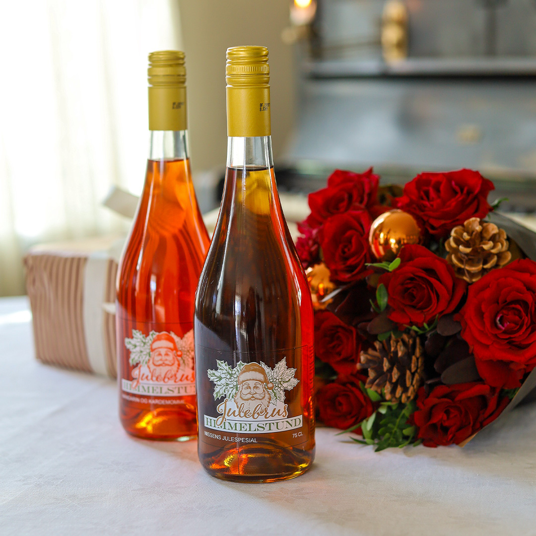 Julebrus Mandarin og Julebrus Spesial på et bord sammen med en julebukett og en gave